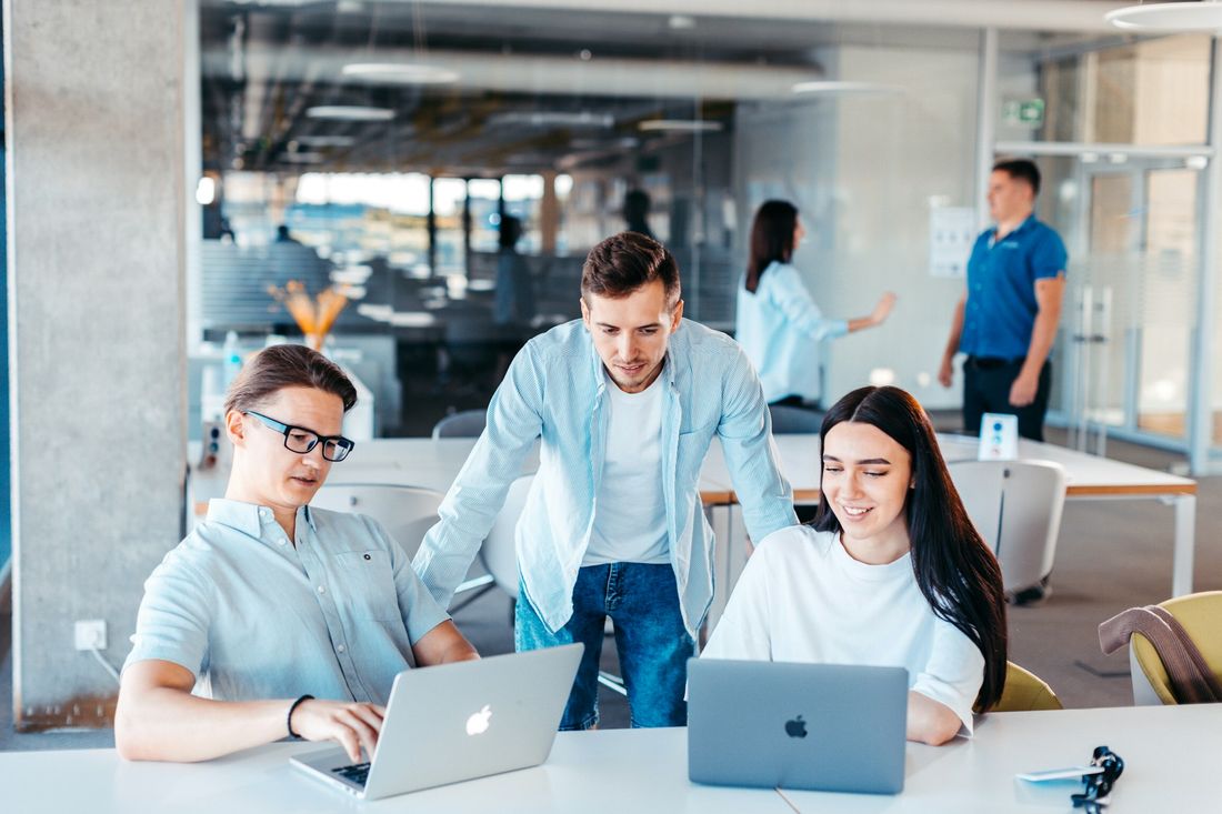 Equipe de desenvolvimento reunida em frente aos computadores